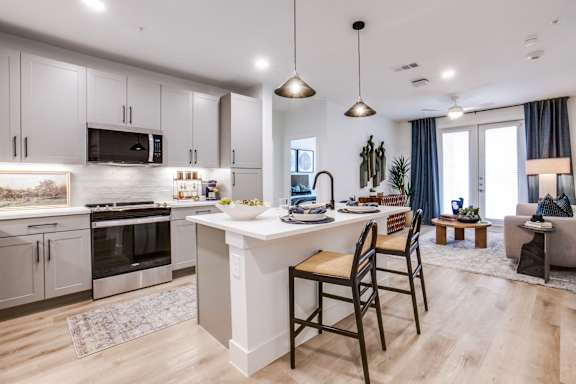 A modern kitchen with a dining area and a living room.