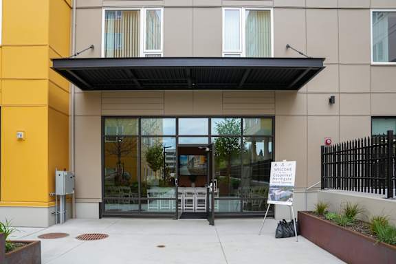A building with a glass door entrance and a sign that says "Welcome to the community.".