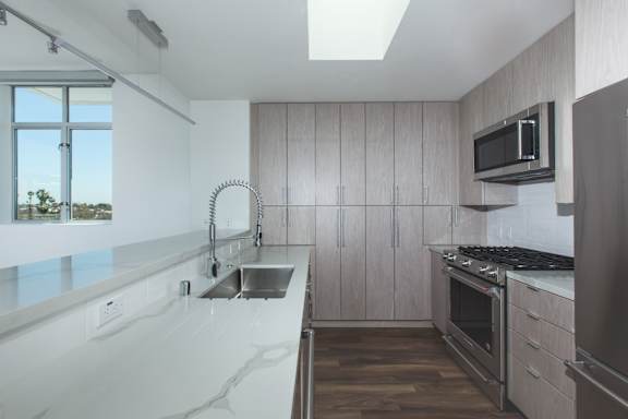 A modern kitchen with wooden cabinets and stainless steel appliances.