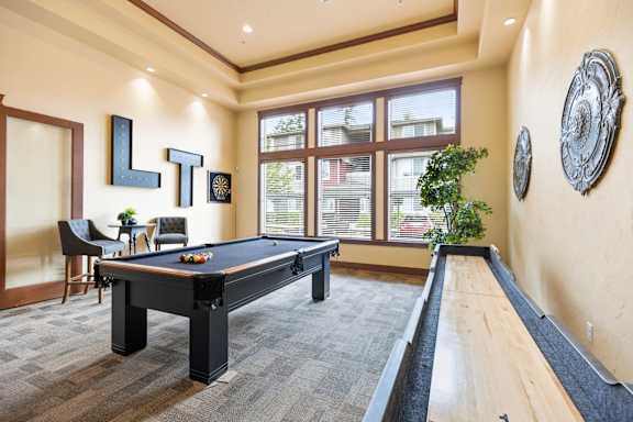 A room with a pool table and a billiard table.