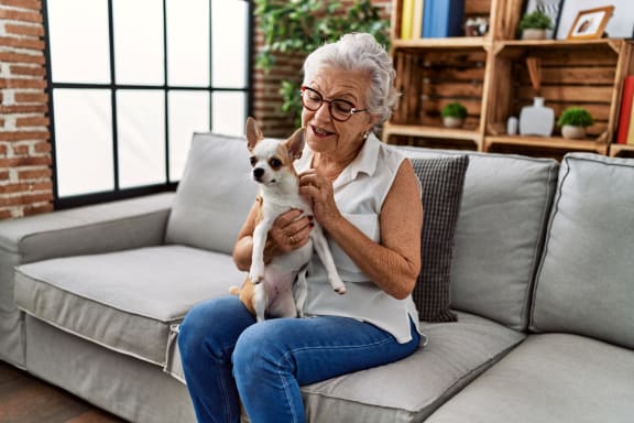 Woman Holding Small Dog and Smiling