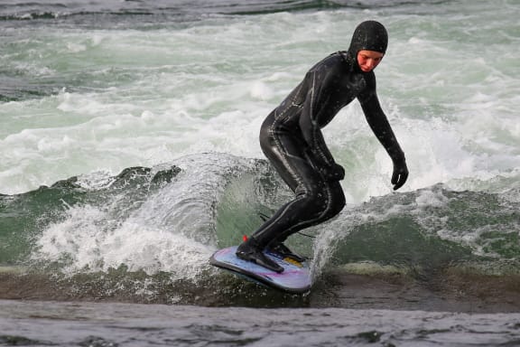 a man riding a wave on top of a surfboard