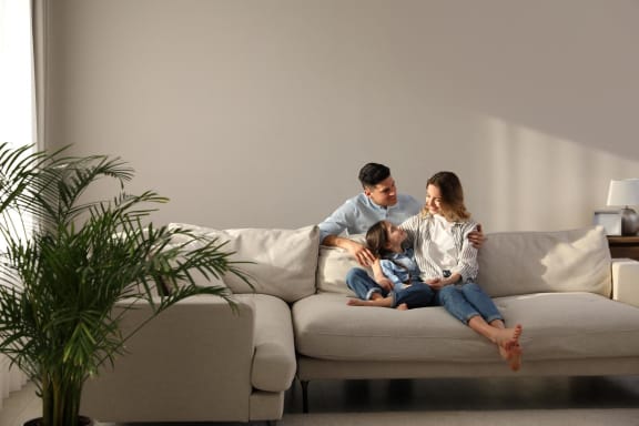 Family Sitting on Couch Together in Living Room