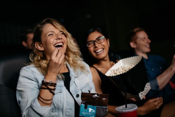 Friends at Movies Eating Popcorn Together