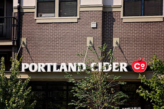 a sign for the cider company on a brick building