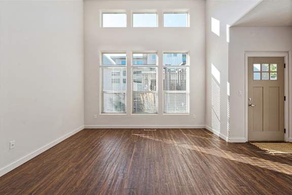 A room with wooden floors and a door leading to another room at Verraso Village Townhomes in Meridian, 83646