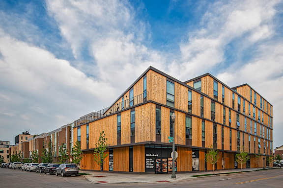 A modern building with a wooden facade and glass windows.