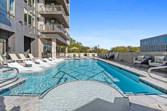 A large outdoor swimming pool with a glass bottom and a metal edge.