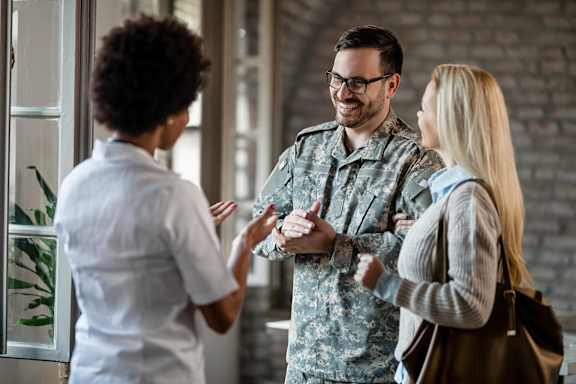 A man in a military uniform is having a conversation with two other people.