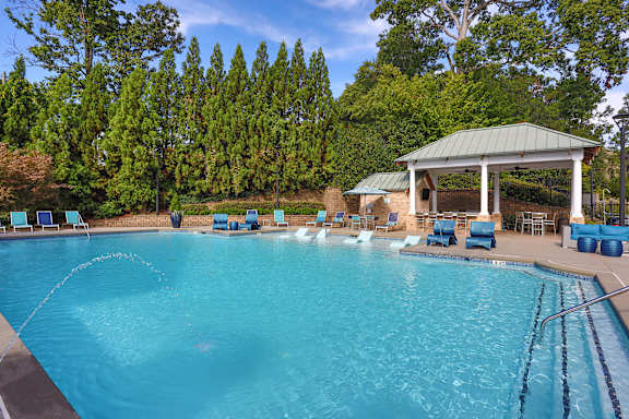 A large swimming pool with a gazebo in the background.