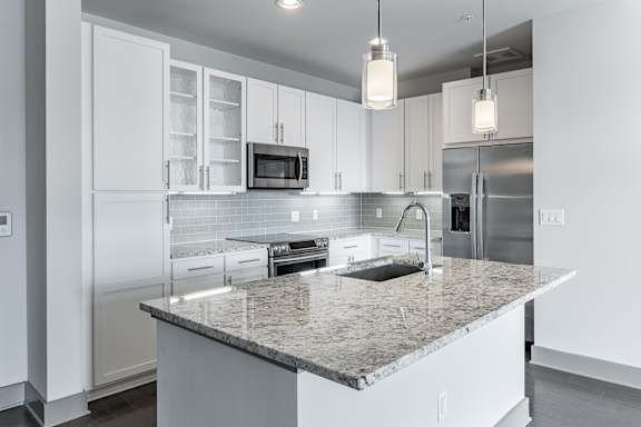 A modern kitchen with granite countertops and stainless steel appliances.