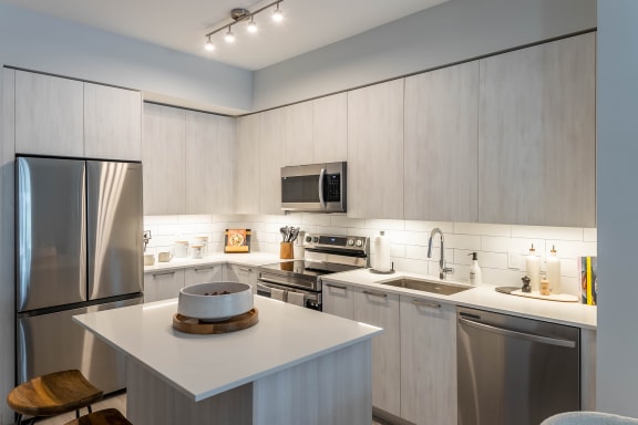 a kitchen with white cabinets and stainless steel appliances