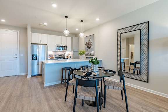 a dining room and kitchen with a table and chairs