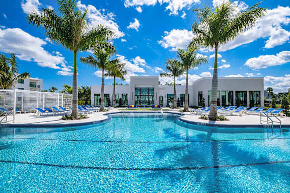 A large swimming pool surrounded by palm trees and sun loungers at Altis Blue Lake, Lake Worth, 33467