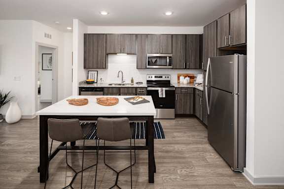 A modern kitchen with a table and chairs in the foreground.