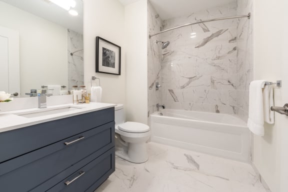 Beverly Apartments- Holmes Beverly- Wall Marble in Shower with Marble Floors and Blue Modern Vanity
