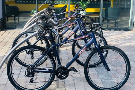 a group of bikes parked on a bike rack