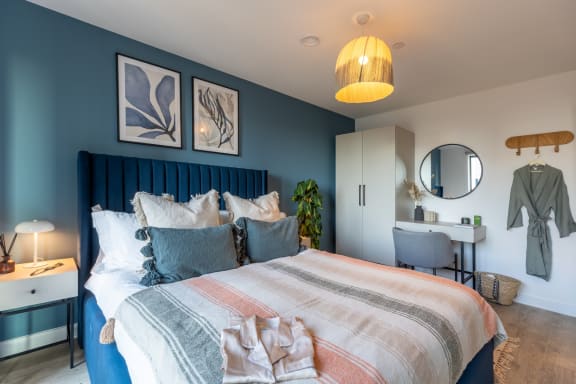 a bedroom with blue walls and a bed with pillows
