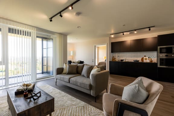 a living room with a couch and chairs and a kitchen