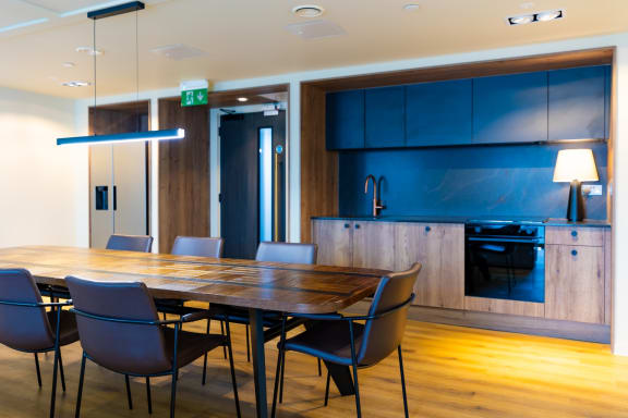 a dining room with blue cabinets and a wooden table and chairs