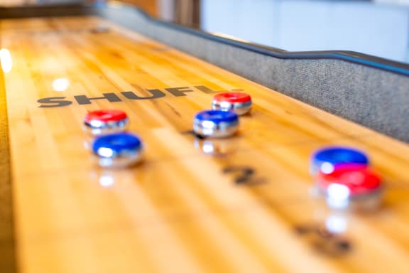a shuffleboard table with blue and red balls on it