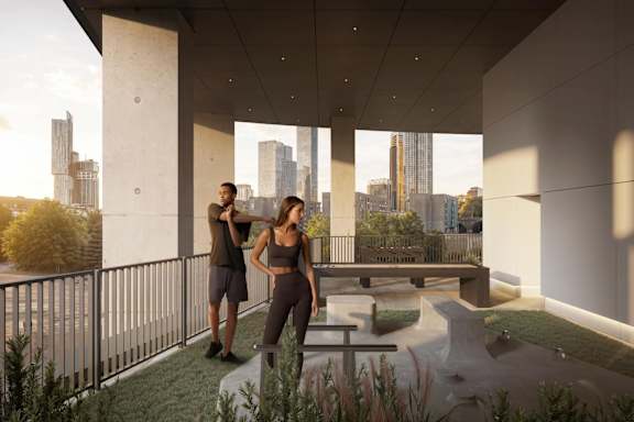 Two people standing on a balcony with a city view.