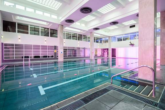 A large indoor swimming pool with a glass bottom.