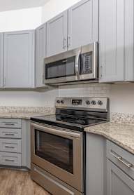 A kitchen with a stove, oven, and cabinets.