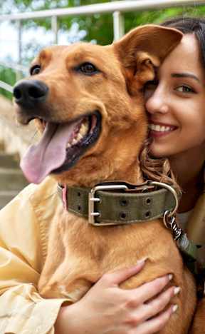 Woman Smiling while Holding Dog