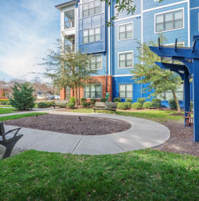 a bench and walkway in front of an apartment building at Streets of Greenbrier in Chesapeake, VA 23320