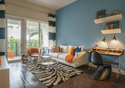 a living room with blue walls and orange and white furniture