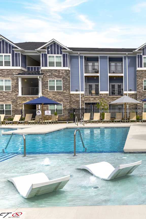 A large swimming pool in front of a building with a sign that says 3 feet.