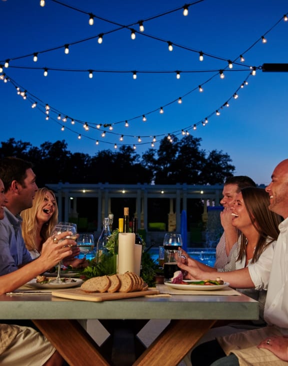 Friends Having Dinner and Wine Together at Dusk