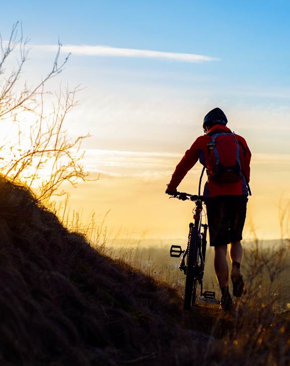 Man Riding Bike on Trail During Sunset