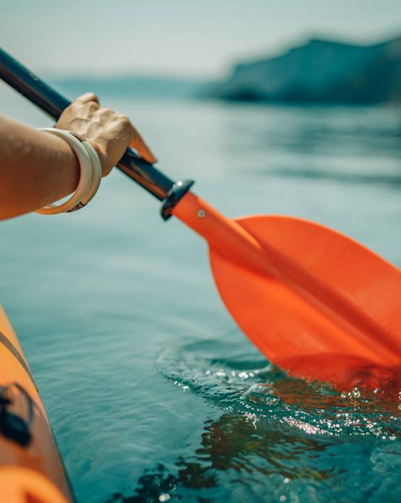Person Paddling Kayak in Water