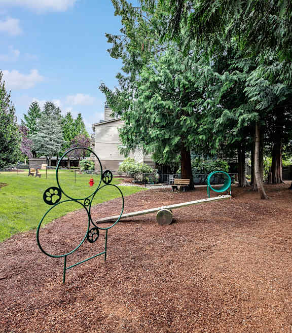 A playground with a swing set and a seesaw.
