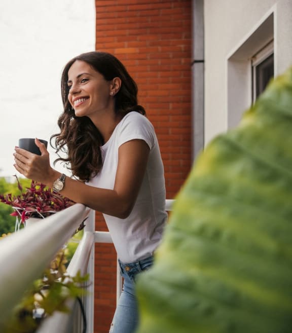 Woman Admiring Views from Apartment Balcony
