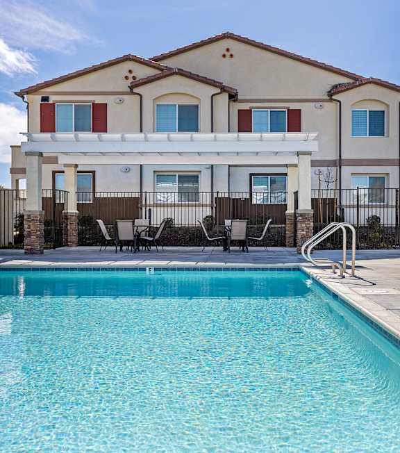 A large house with a pool in front.