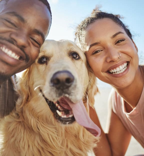 Man and Woman Smiling with Pet Dog