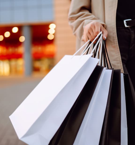 A person is holding several shopping bags.