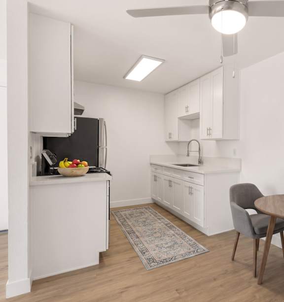 A modern kitchen with a stainless steel refrigerator and a white countertop.