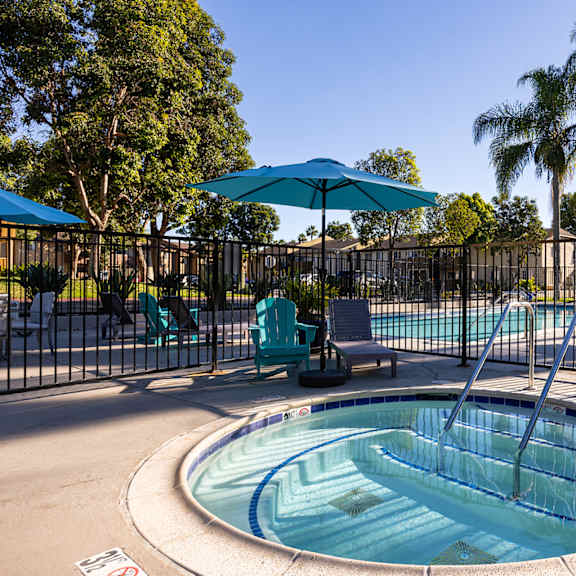 A pool with a slide and a fence.