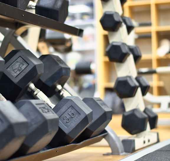 A set of black dumbbells with the number 35 on them are on a rack.