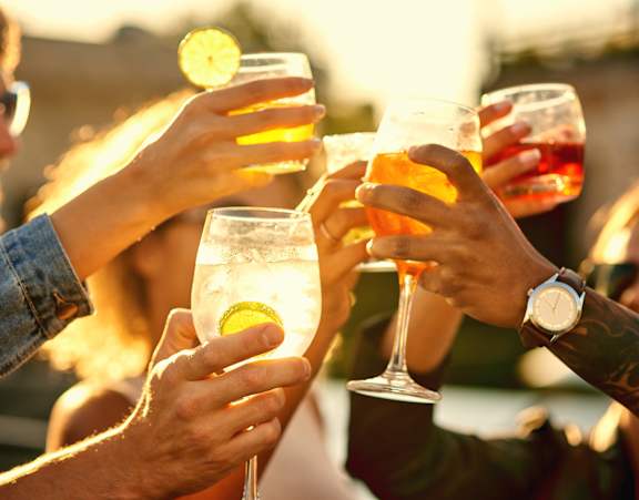 A group of people toasting with drinks in their hands.