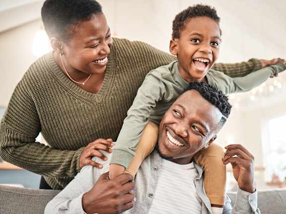 A man is giving a piggyback ride to a child on his shoulders.