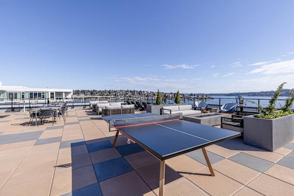 a terrace with a ping pong table and a view of the water