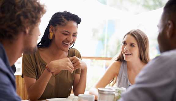 Four people sitting around a table having a conversation.