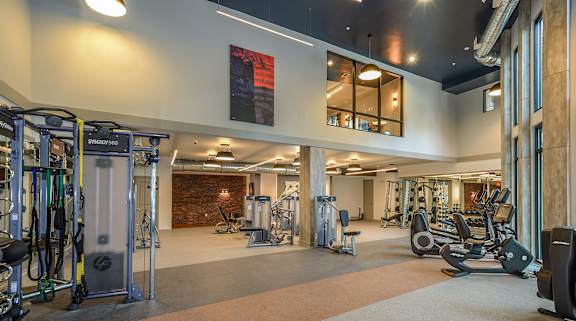 A gym with a variety of equipment including treadmills, weights, and exercise machines.