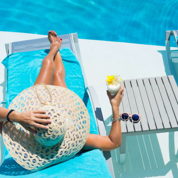 Woman Laying by Pool with Drink