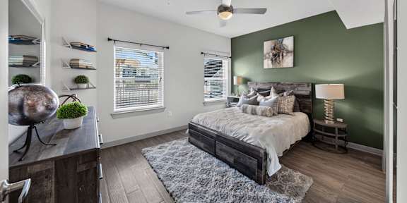 a bedroom with a bed and two windows